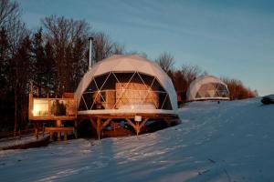 dos cúpulas en la nieve en un campo cubierto de nieve en mi-clos - luxury pods with private jacuzzis en Orford