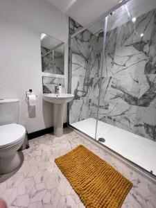 a bathroom with a shower and a toilet and a sink at Maxwell's Corner, Modern Coastal Apartment in North Shields