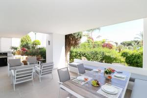 een eetkamer met een tafel en stoelen bij Los Monteros Palm Beach - ground floor apartment in Marbella