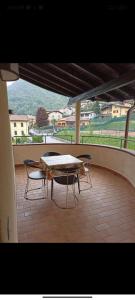 einen Tisch und Stühle auf einem Balkon mit Tisch und Stühlen in der Unterkunft EderaHouse in Cerano d'Intelvi
