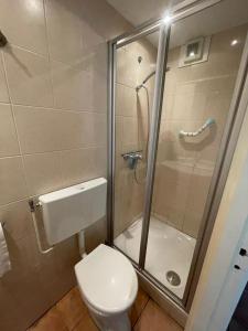 uma casa de banho com um WC e uma cabina de duche em vidro. em Vakantiehuisje Martina 17 em Vlissingen