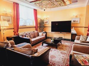 a living room with couches and a flat screen tv at Alexa Hotel in Göhren