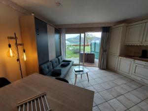 sala de estar con mesa y sofá en Rare : au bord du lac d’Annecy, cosy appartement en rez de jardin avec terrasse privative, en Duingt