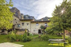a stone house with a picnic table in a yard at Locanda Del Silenzio Residence in Macra