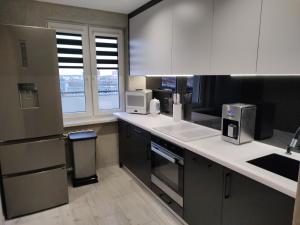 a kitchen with white cabinets and a counter top at Apartament MERCURY in Ełk