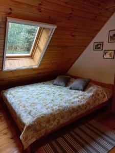Cama en habitación con ventana en Fajny Domek w Nartach, en Narty