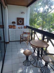 a balcony with two tables and chairs in a kitchen at Flat TOP em Itaparica in Itaparica Town