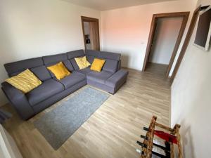 a living room with a blue couch and yellow pillows at Apartmány u Moravčíků in Bulhary