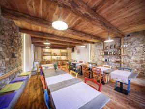 a dining room with tables and chairs and a stone wall at Locanda Del Silenzio Residence in Macra
