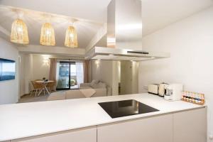 帕拉莫斯的住宿－Gran piso en Puerto deportivo Marina Palamós IDEAL FAMILIAS，一间带白色台面的厨房和一间客厅