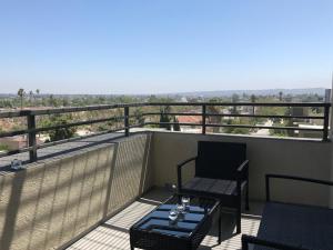 balcón con mesa, sillas y vistas en Central Apartment en Los Ángeles