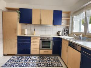 a kitchen with blue cabinets and a tile floor at AMS Apartments The Royal Blue in Spaichingen