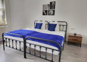 a bedroom with a bed with blue and white pillows at AMS Apartments The Royal Blue in Spaichingen