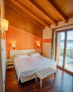 a bedroom with a large bed and a large window at Hotel Ristorante Vecchia Riva in Varese