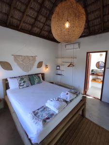 a bedroom with a large bed with white sheets at Chill Kite - Icaraí Kite Village in Icaraí
