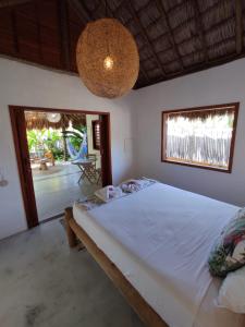 a bedroom with a large white bed and a patio at Chill Kite - Icaraí Kite Village in Icaraí