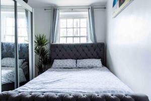 ein Schlafzimmer mit einem großen Bett und einem Spiegel in der Unterkunft Lovely flat in Crouch End in London