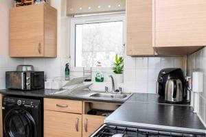 a kitchen with a sink and a stove top oven at Lovely flat in Crouch End in London