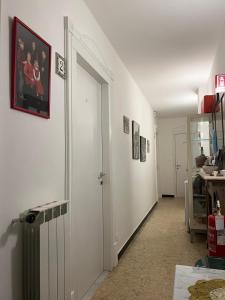 a hallway with white walls and a door with pictures on it at dreamingrooms in Riomaggiore