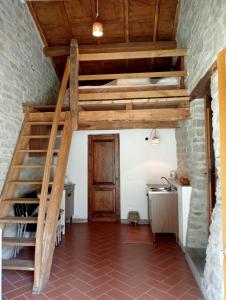 Habitación con cama elevada y escalera de madera. en Rocca Corneta, en Palazzuolo sul Senio