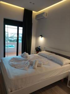 een slaapkamer met een groot wit bed en handdoeken bij Villa Vento in Ksamil