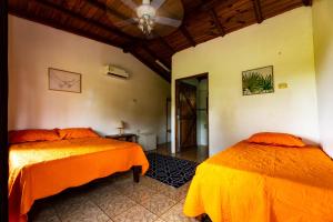 1 dormitorio con 2 camas y ventilador de techo en Oso de Osa Finca y Eco-Resort, en Sierpe