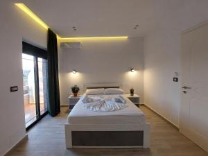een slaapkamer met een bed en een groot raam bij Villa Vento in Ksamil