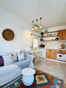 a living room with a couch and a kitchen at Jakaranda Unique Apart in Bodrum City