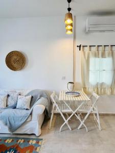 a living room with a couch and a table and chairs at Jakaranda Unique Apart in Bodrum City +13 photos