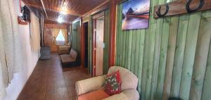 ein Wohnzimmer mit einem Sofa und einer grünen Wand in der Unterkunft Alojamiento Machicura in Linares