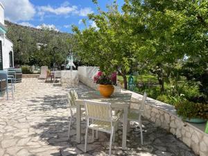 un tavolo con sedie e un vaso di fiori sopra di B&B Casa Vacanza Orchidea vicino a Mattinata Gargano a Monte SantʼAngelo