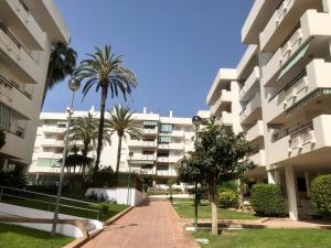 een groot appartementencomplex met palmbomen ervoor bij Carihuela Playa, Torremolinos in Torremolinos