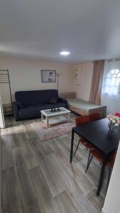 uma sala de estar com um sofá azul e uma mesa em kaon nil em Gerzat