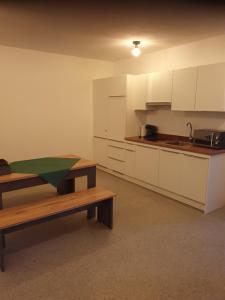 a kitchen with white cabinets and a bench and a sink at Gutshof Seenland in Seekirchen am Wallersee