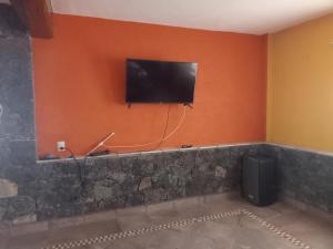 Habitación con TV de pantalla plana en la pared en Descansó entre las montañas....., en Tepoztlán
