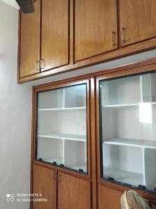 a wooden cabinet with two glass windows at Anve's Airport Nest in Visakhapatnam