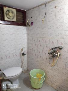 a bathroom with a toilet and a bucket at Anve's Airport Nest in Visakhapatnam