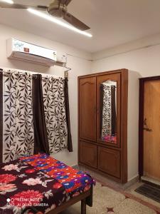 um quarto com uma cama e um armário de madeira em Anve's Airport Nest em Visakhapatnam