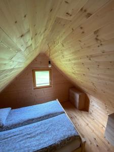 ein Schlafzimmer mit einem Bett in einer Holzhütte in der Unterkunft Brunarica Jeršin in Cerkno