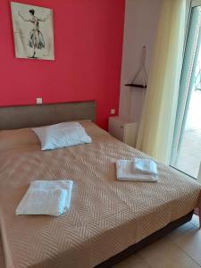 a bedroom with a bed with two towels on it at Golden Horizon Haven in Preveza