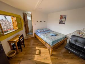 ein Schlafzimmer mit einem Bett und einem Schreibtisch. in der Unterkunft Hostal Bambu in San Agustín