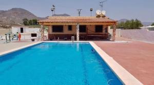 ein Pool mit einem Gebäude im Hintergrund in der Unterkunft Villa Águilas in Águilas