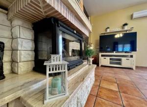 a living room with a fireplace and a tv at Villa vacacional Águilas in Águilas