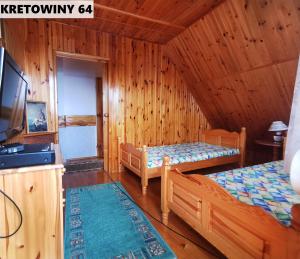 - une chambre avec 2 lits dans une cabane en rondins dans l'établissement Duży Domek Nad Jeziorem - Kretowiny 64, à Kretowiny