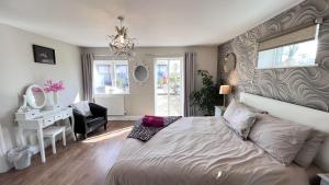 a bedroom with a bed and a desk and a mirror at Runway Cottage in Coningsby