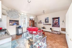 uma sala de estar com uma mesa de vidro e um sofá vermelho em La casetta rossa Desenzano del Garda em Desenzano del Garda
