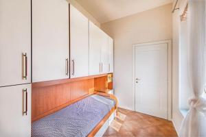 een slaapkamer met een bed en witte kasten bij La casetta rossa Desenzano del Garda in Desenzano del Garda