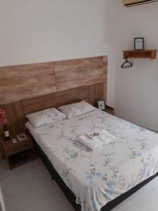 a bedroom with a bed with a wooden headboard at Kitnet - Apart Hotel 3 in Sete Lagoas