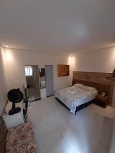 a bedroom with a bed and a table and a couch at Kitnet - Apart Hotel 3 in Sete Lagoas