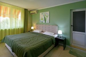 ein Schlafzimmer mit einem großen Bett mit grünen Wänden in der Unterkunft Villa Holiday in Baltschik